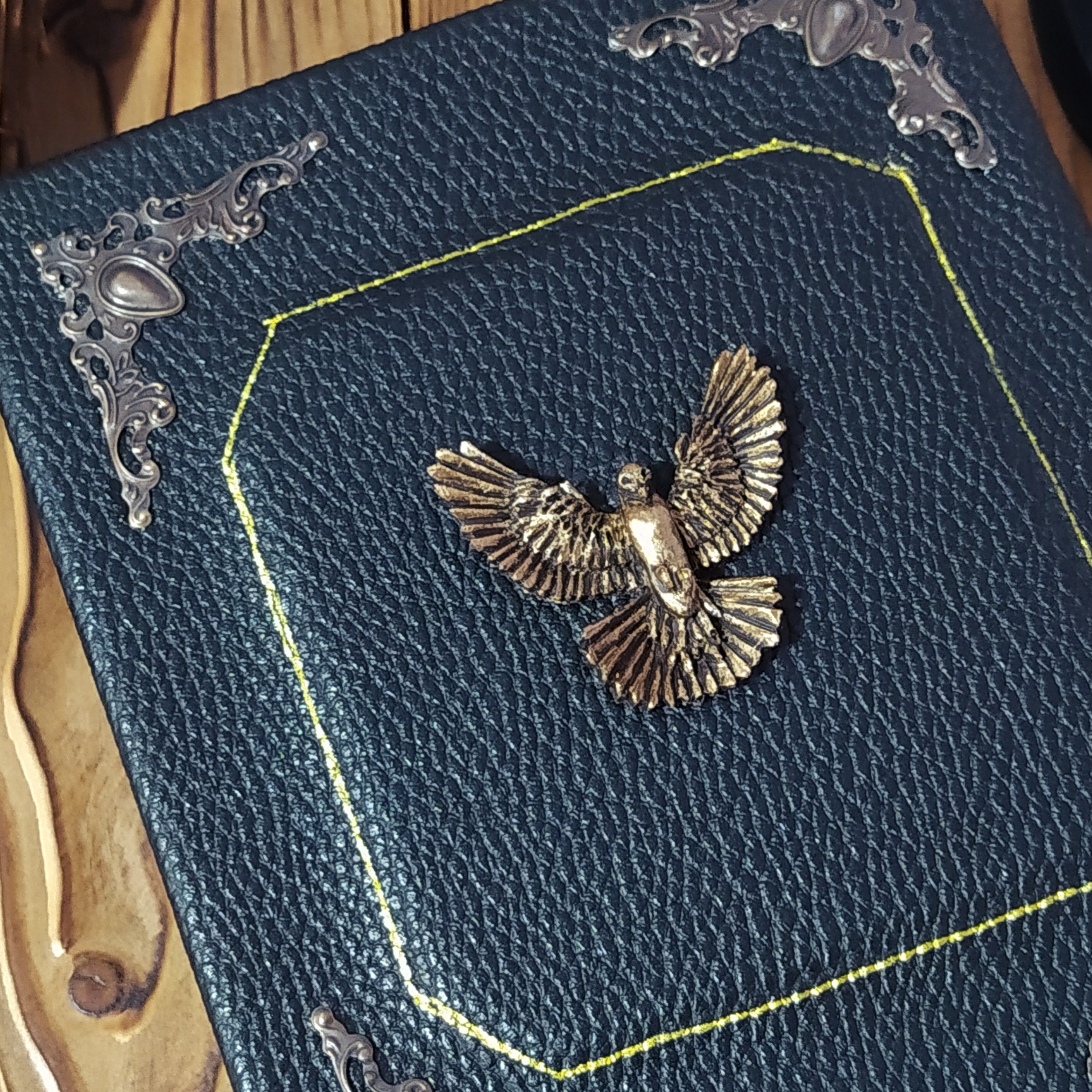 کلاسور جلد سخت چرمی 21  در  16 چرم مشکی  اکسسوری کبوتر دست ساز  پتینه کاری برنزی به همراه صد برگ کاغذ خط دار نخودی 