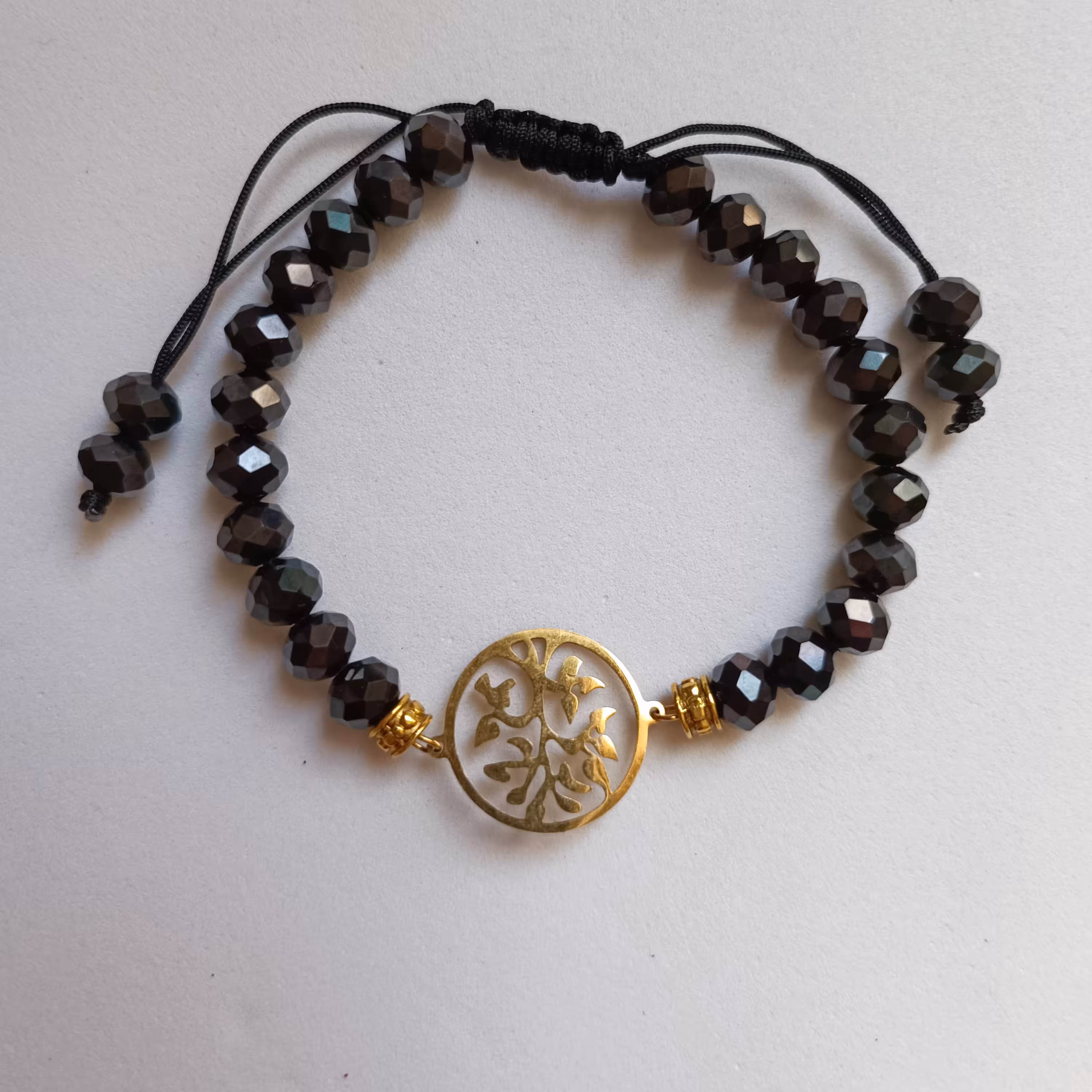 دستبند کریستال تراش مشکی با پلاک استیل طلایی رنگ ثابت به صورت کشویی باز و بسته میشود و قفل ندارد 