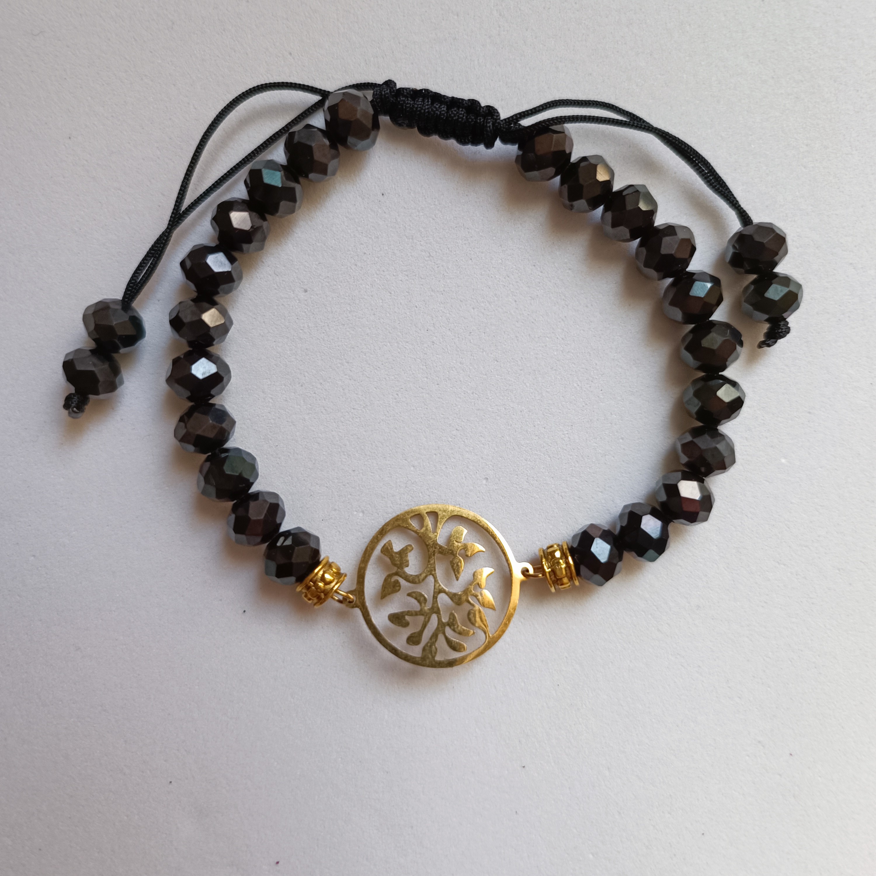 دستبند کریستال تراش مشکی با پلاک استیل طلایی رنگ ثابت به صورت کشویی باز و بسته میشود و قفل ندارد 