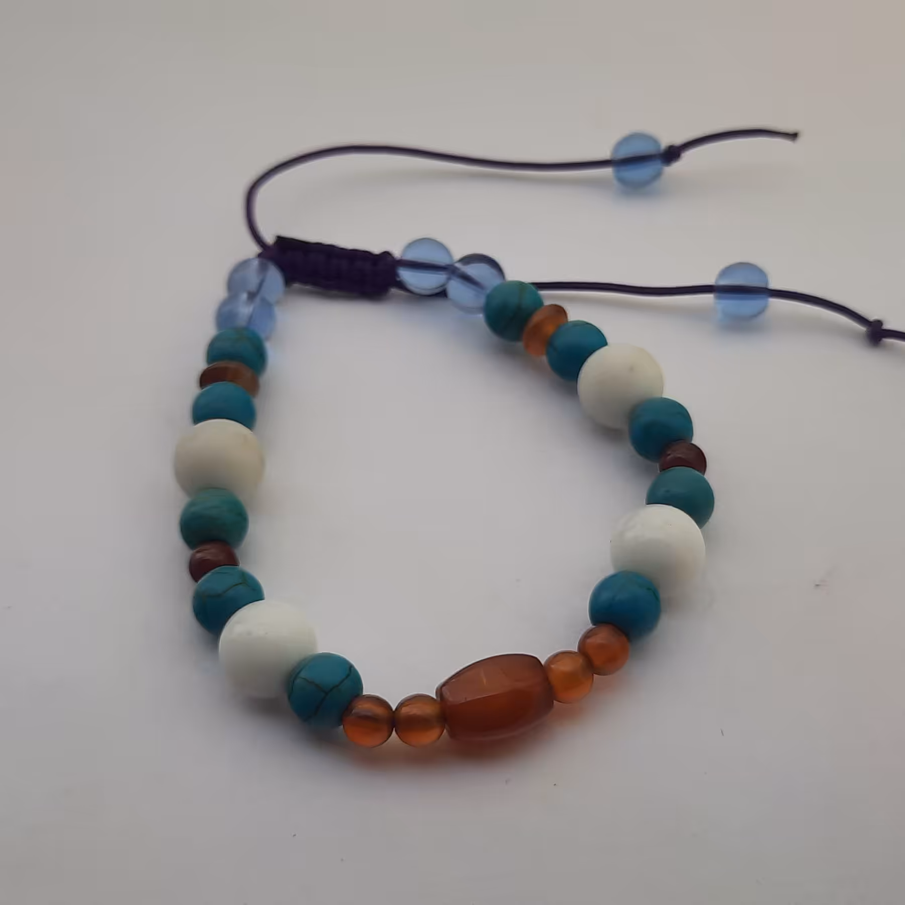 دستبند تلفیقی سنگ و کریستال کد ب3 با قابلیت تغییر سایز با مرکزیت سنگ عقیق سرخ رنگ بند بنفش