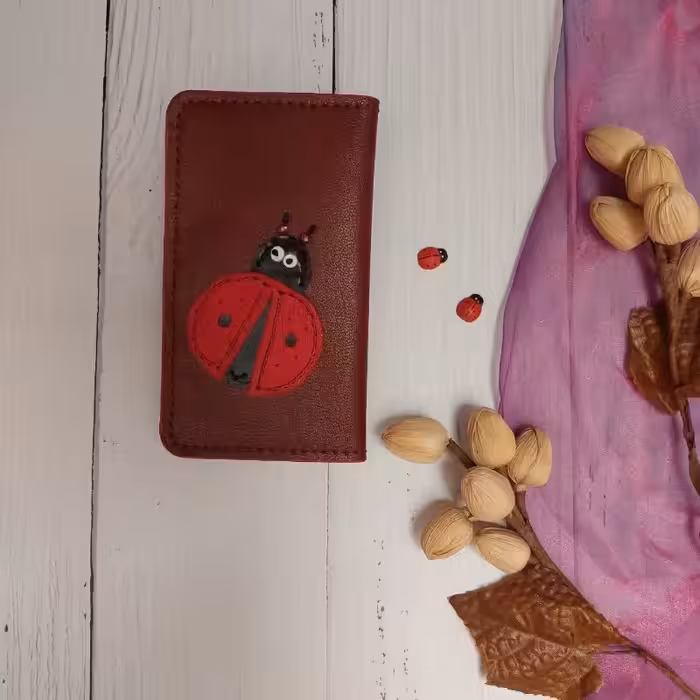 کیف پول کفشدوزک  ساخته شده از چرم طبیعی بزی  دارای 6 جای کارت و دو قسمت برای اسکناس 