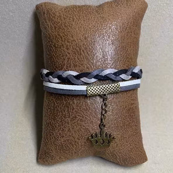 دستبند تریشه چرمی مدل بافت 4 رنگ خاکستری کم رنگ و پر رنگ و سیاه و سفید با زنجیر و خرج کار برنزی طرح تاج