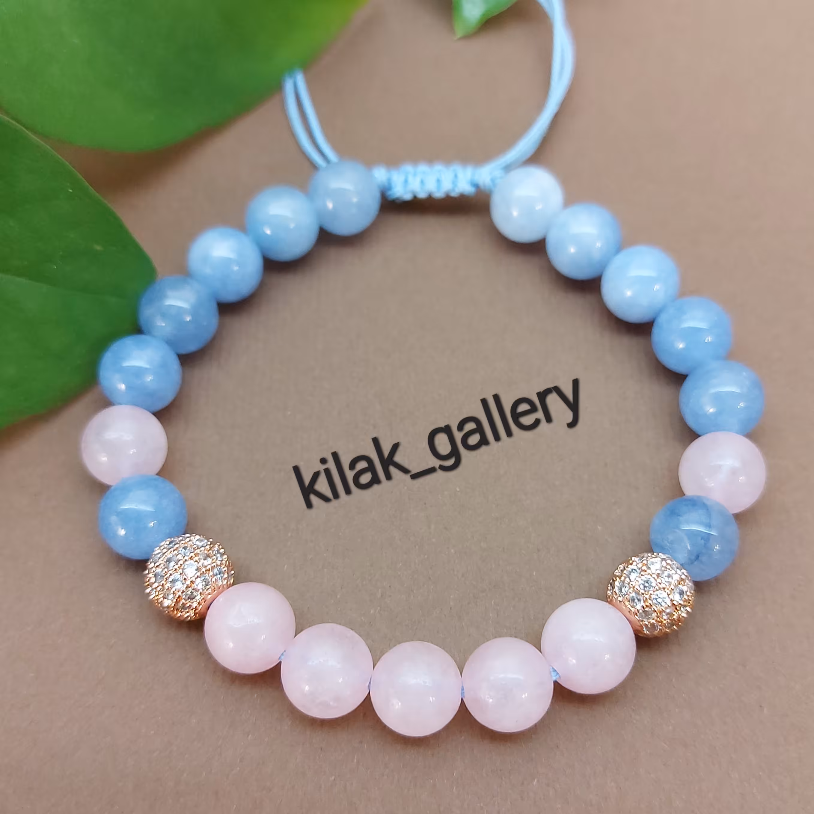 دستبند سنگی متولدین اسفند با سنگ آکوآمارین و رزکوارتز و دو عدد گوی سوارسکی رزگلد