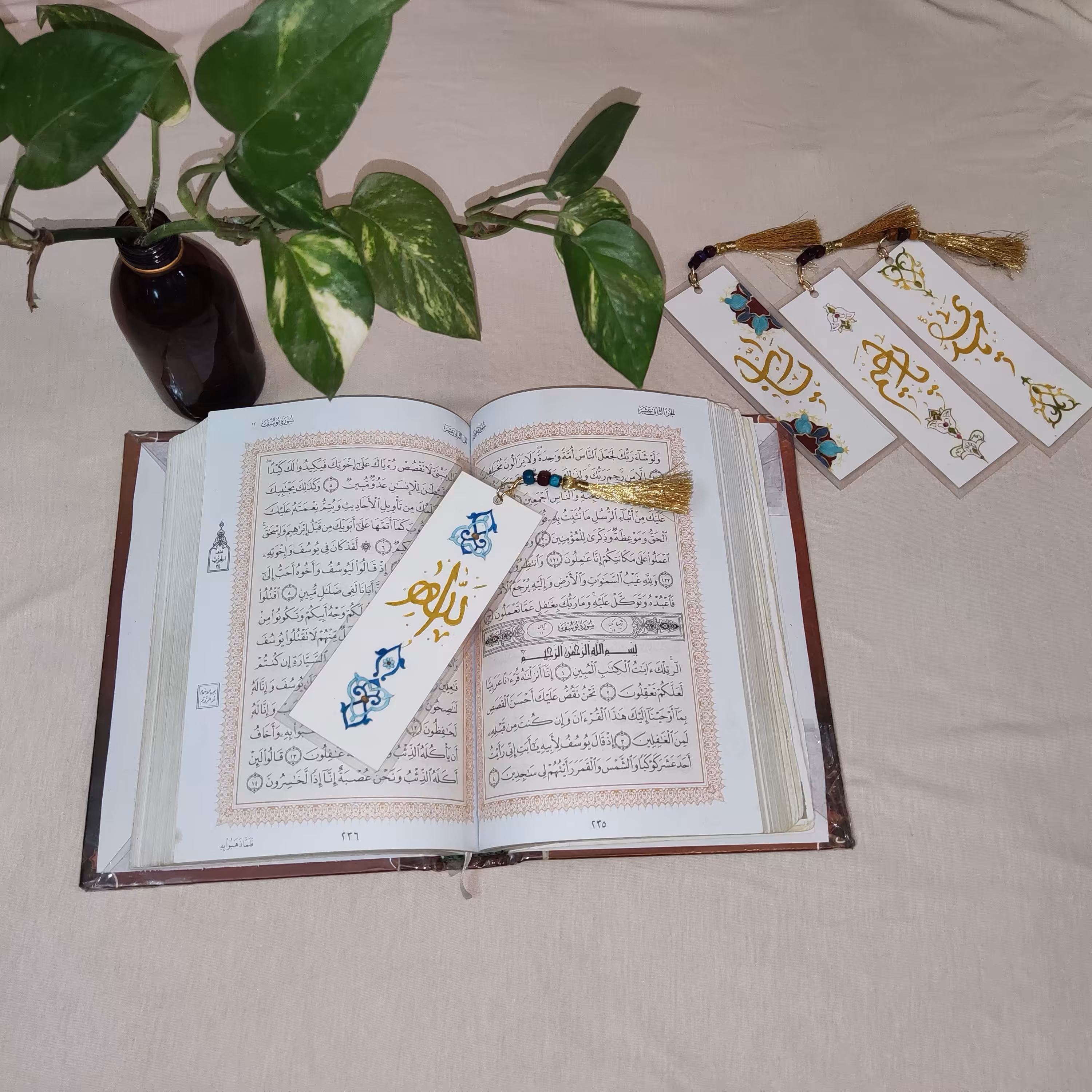 بوک مارک (نشانگر کتاب) خطاطی شده و تذهیب شده و پرس شده و دارای منگوله و مهره