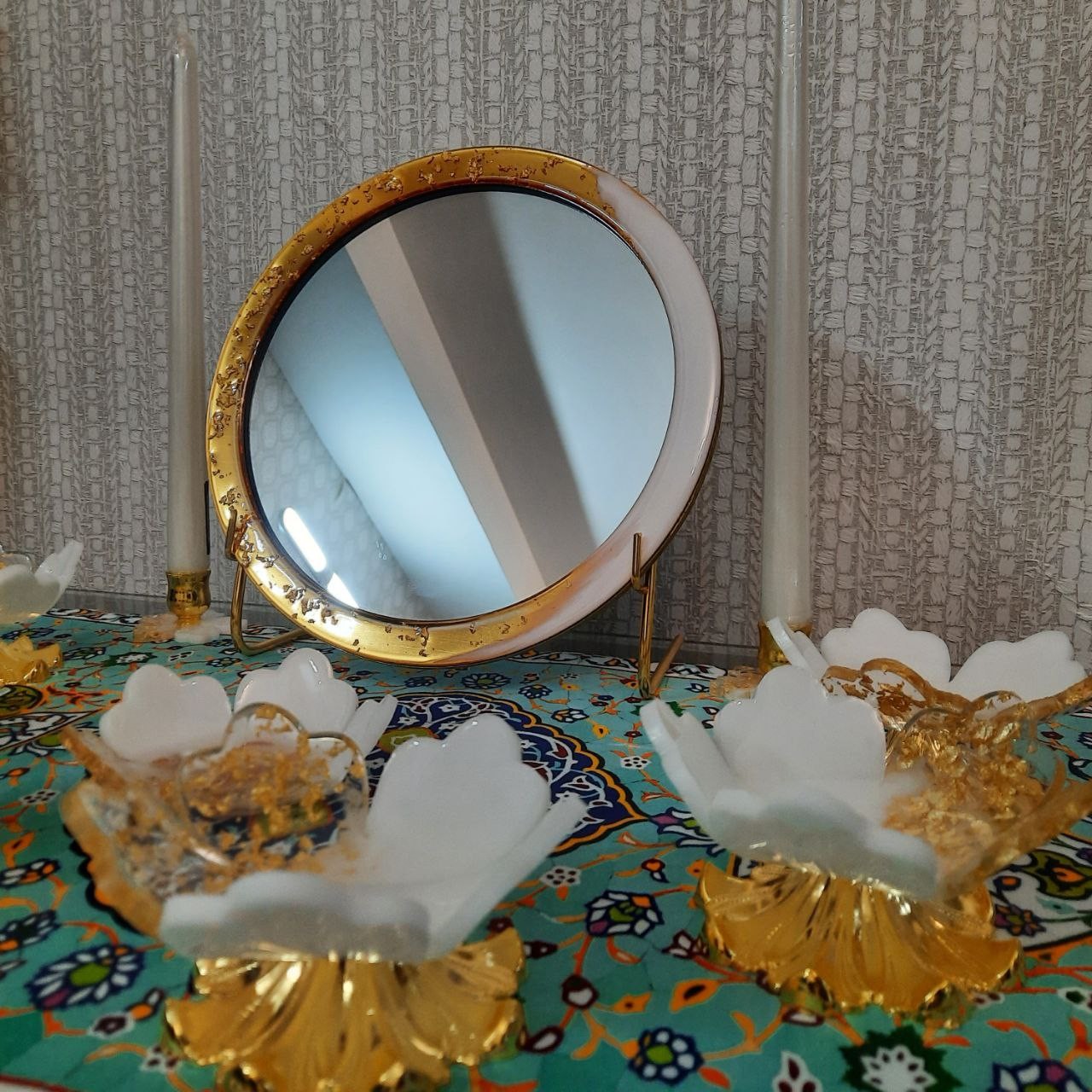 هفت سین رزینی طلا ساخته شده از ورق طلا ،پایه آینه فلزی آبکاری شده،پایه ی کار طرح زنبق است 