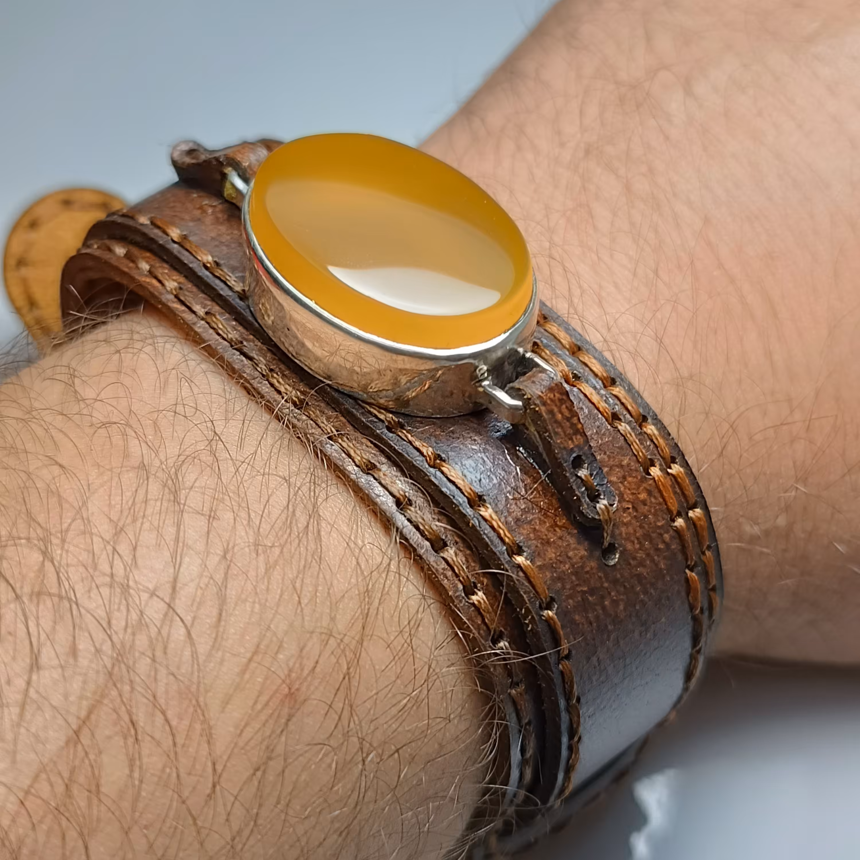 دستبند چرم با نگین عقیق زرد و رکاب دست ساز نقره 