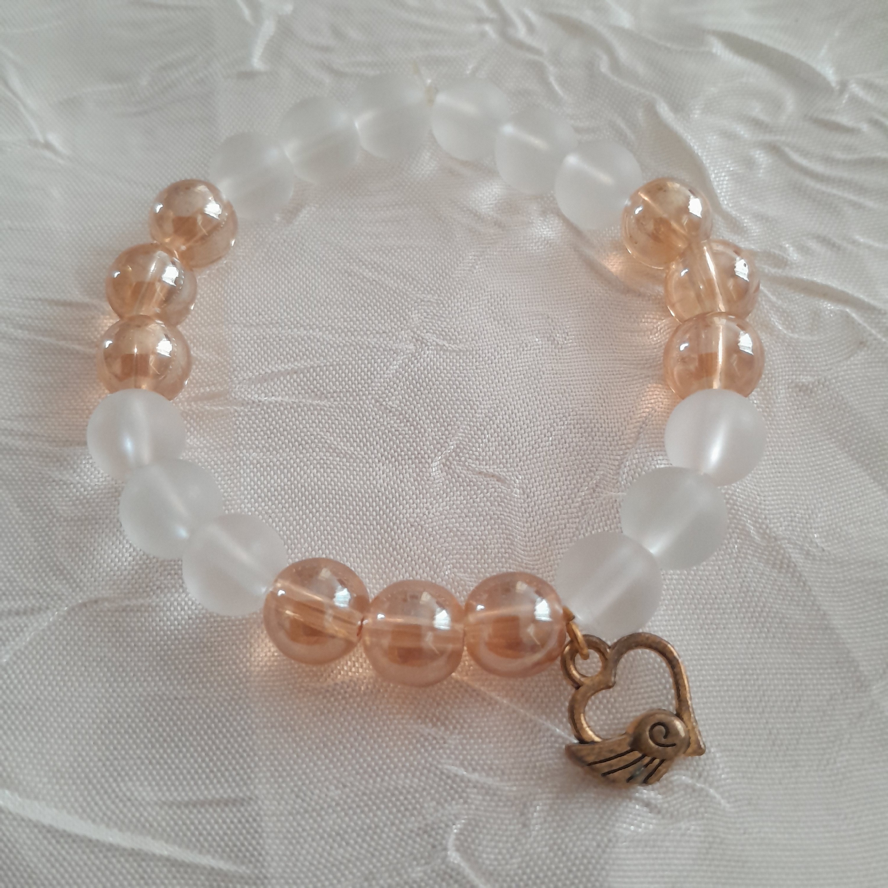 دستبند کشی با مهره های اونیکس یخی و شامپاین براق و آویز قلب