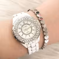 ساعت مچی  زنانه و دخترانه چنل  نگین دار  طرح سرامیکی سفید همراه با دستبند حدید قلبی لاکچری و جدید زیبا 