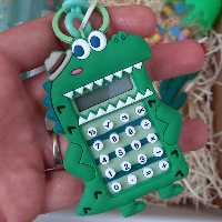 ماشین حساب فانتزی طرح دایناسور  به همراه بازی و اویز کلید در رنگ های سبز و ابی و نارنجی