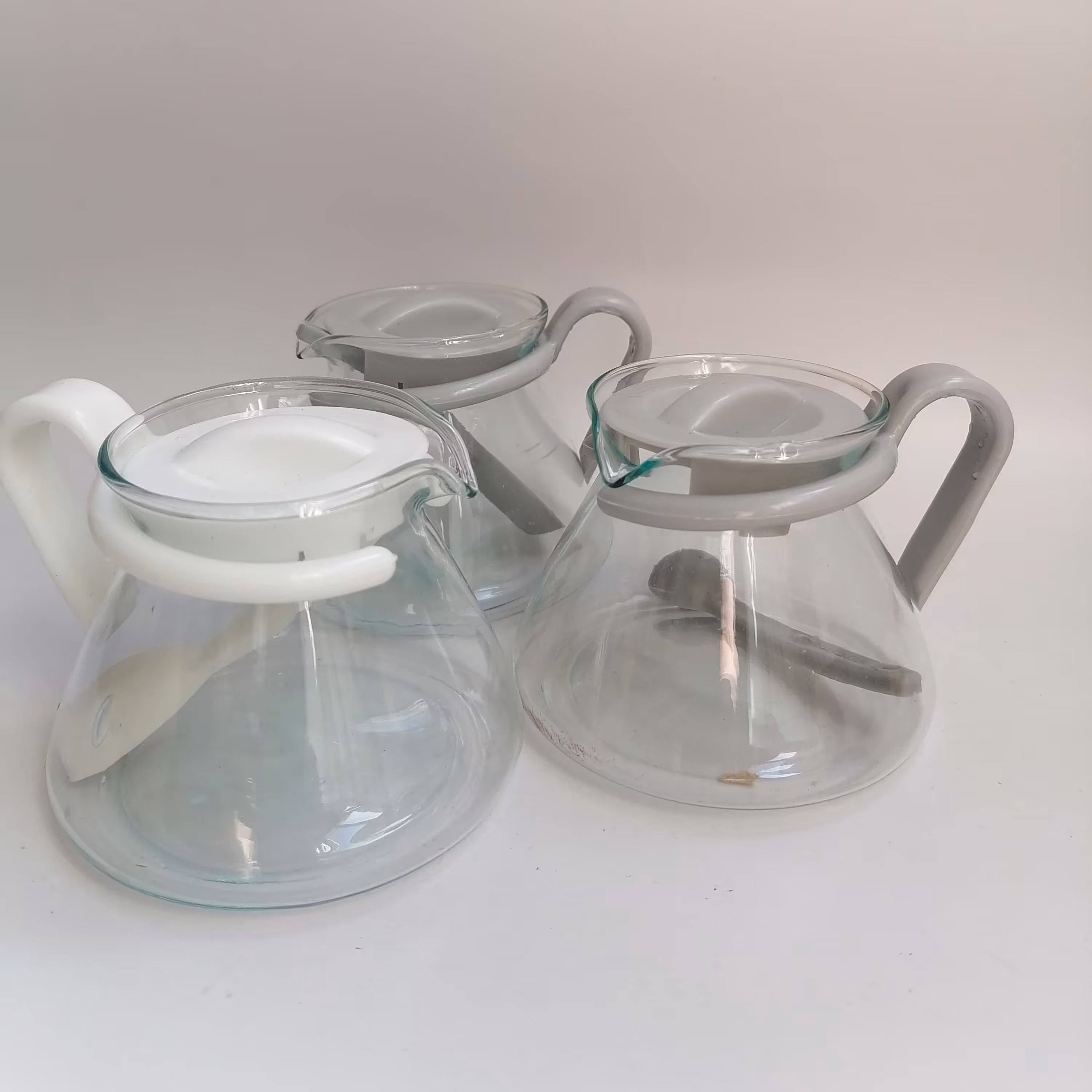 قوری پیرکس زعفران در رنگهای طوسی و سفید و دارای قاشق داخل قوری