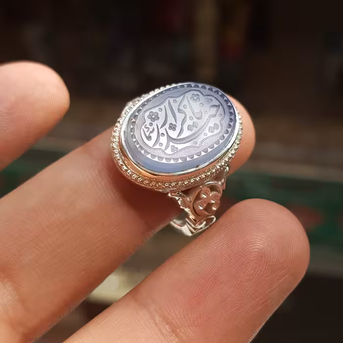 نگین عقیق یمن خط استاد سما رکاب دست ساز مدل 3گل به همراه حرز امام جواد علیه السلام تربت امام حسین علیه السلام زیر نگین 