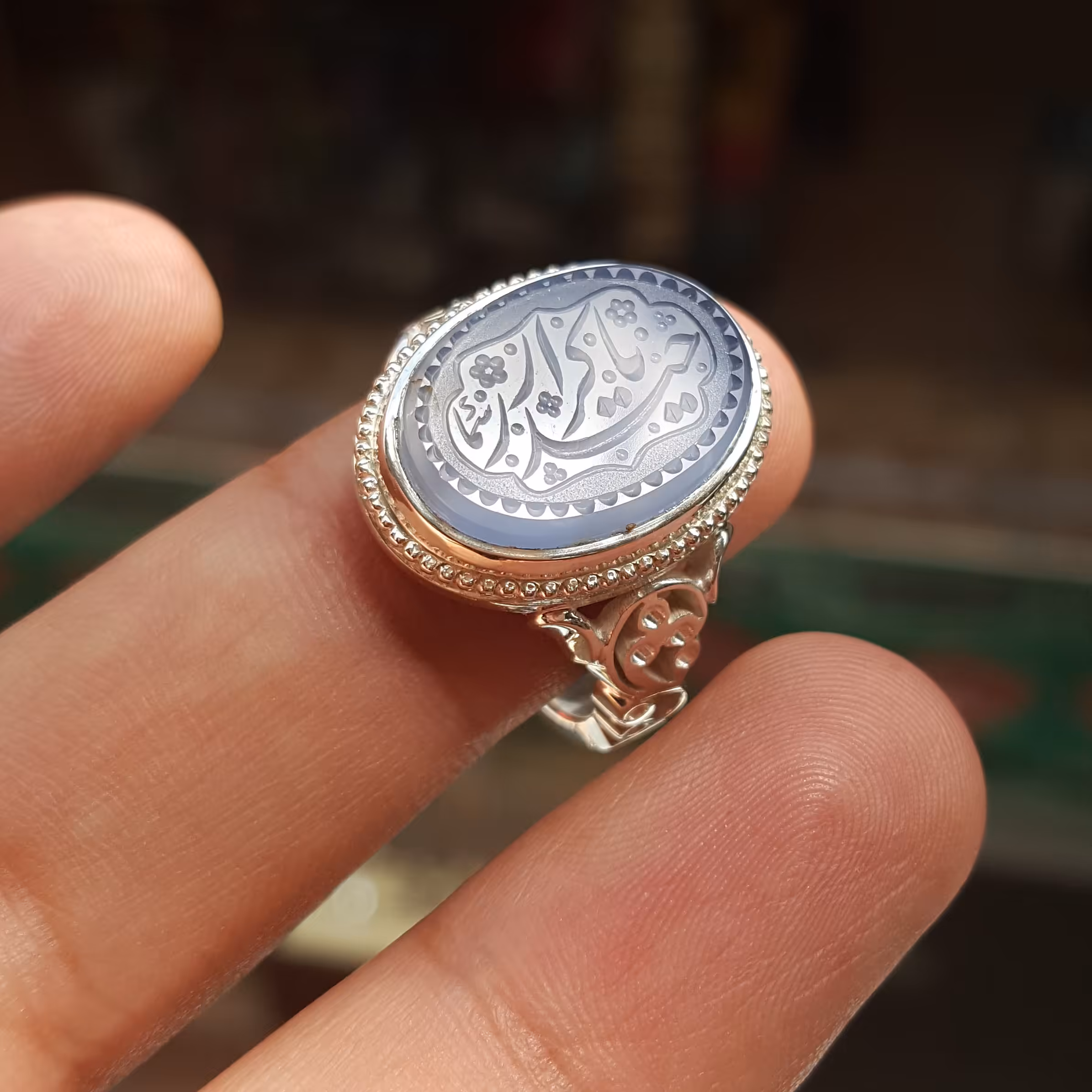 نگین عقیق یمن خط استاد سما رکاب دست ساز مدل 3گل به همراه حرز امام جواد علیه السلام تربت امام حسین علیه السلام زیر نگین 