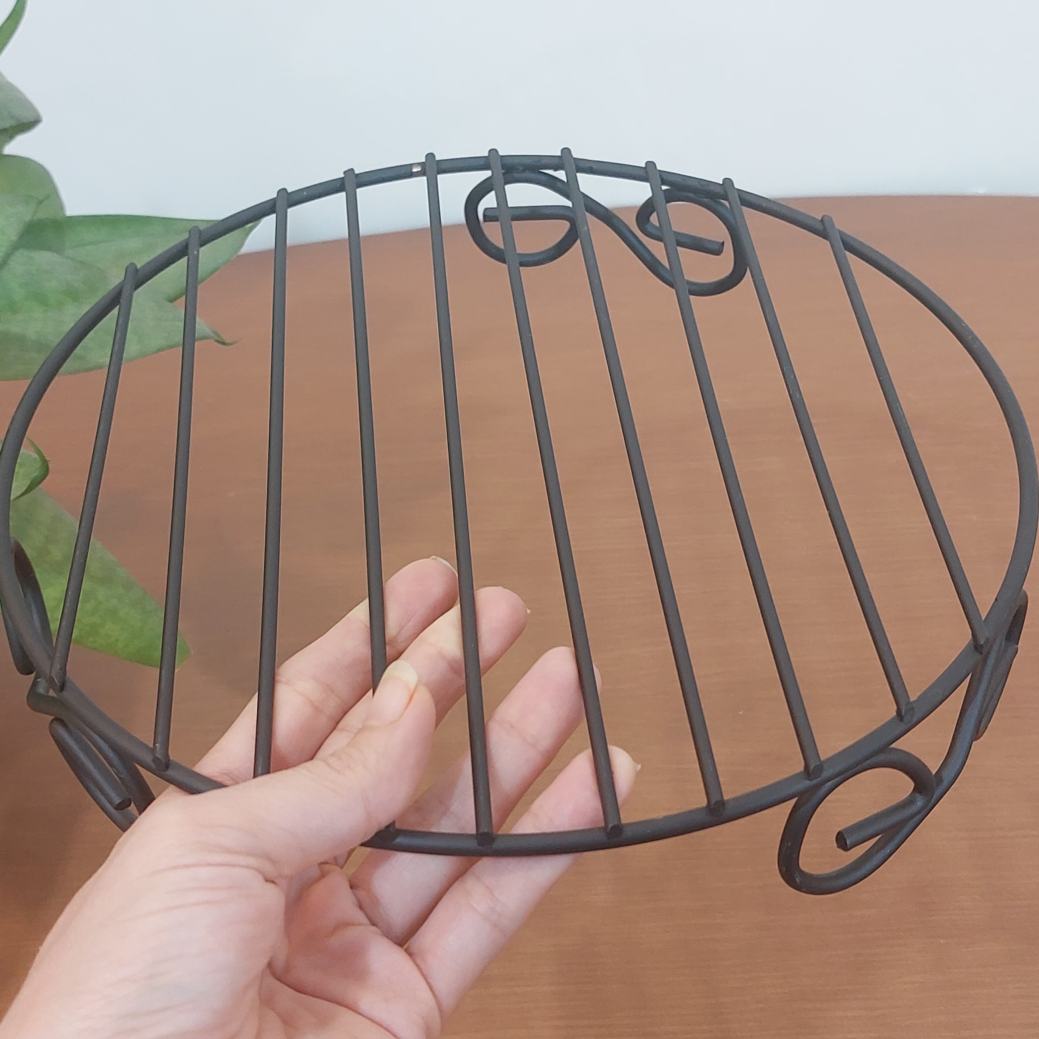 زیر قابلمه ای فلزی مشکی رنگ دایره ای شکل زیر قابلمه ای پایه دار