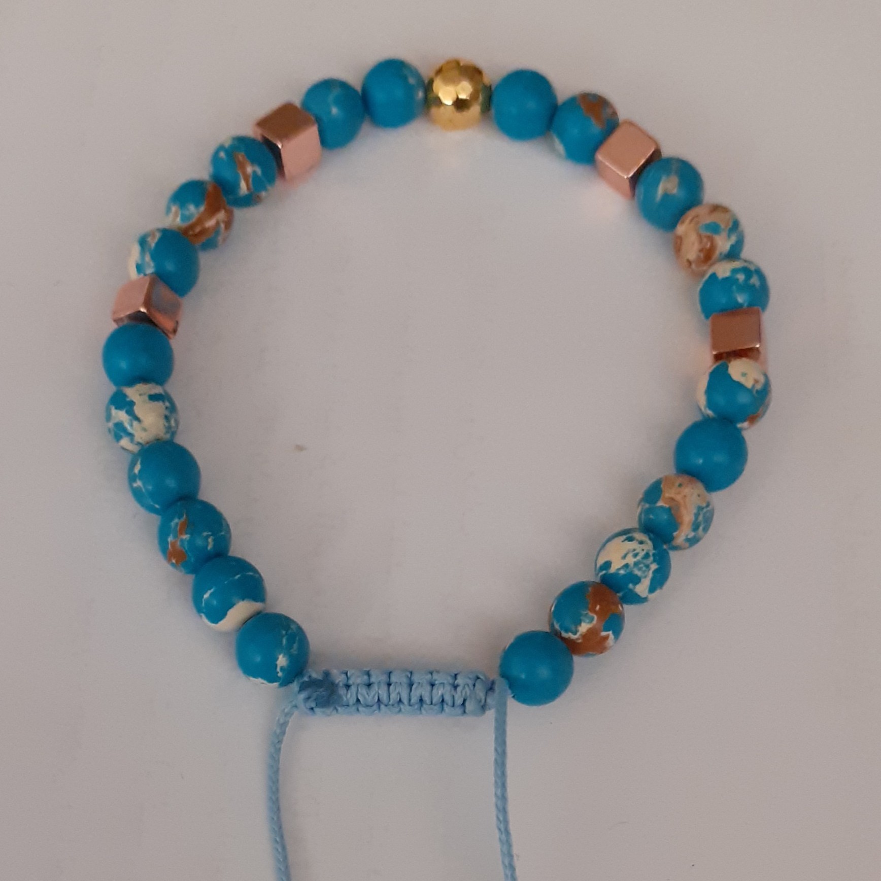 دستبند سنگ اصل فیروزه تبتی با بند بافت که به راحتی قابل تغییر سایز هست 