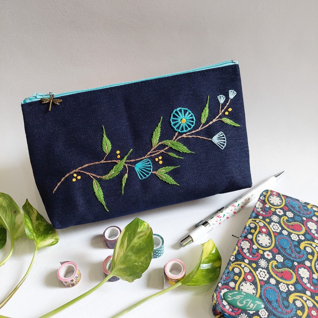 جامدادی کیف آرایش لی گلدوزی شده با دست دست دوز پارچه ای طرح شاخه گلهای آبی چرخ دنده ای