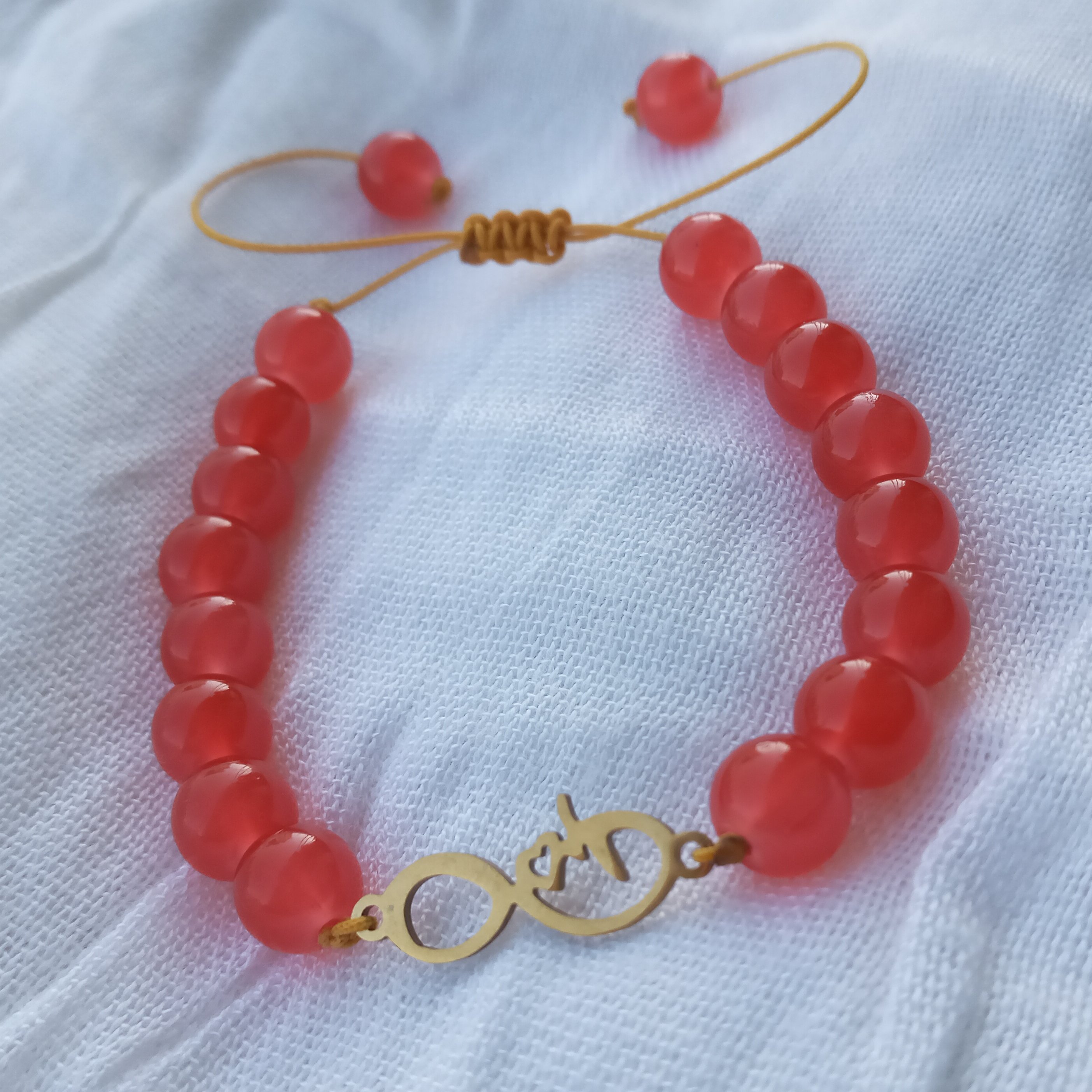 دستبندپلاک  استیل بی نهایت نخی همراه مرواریدقرمز سایز8