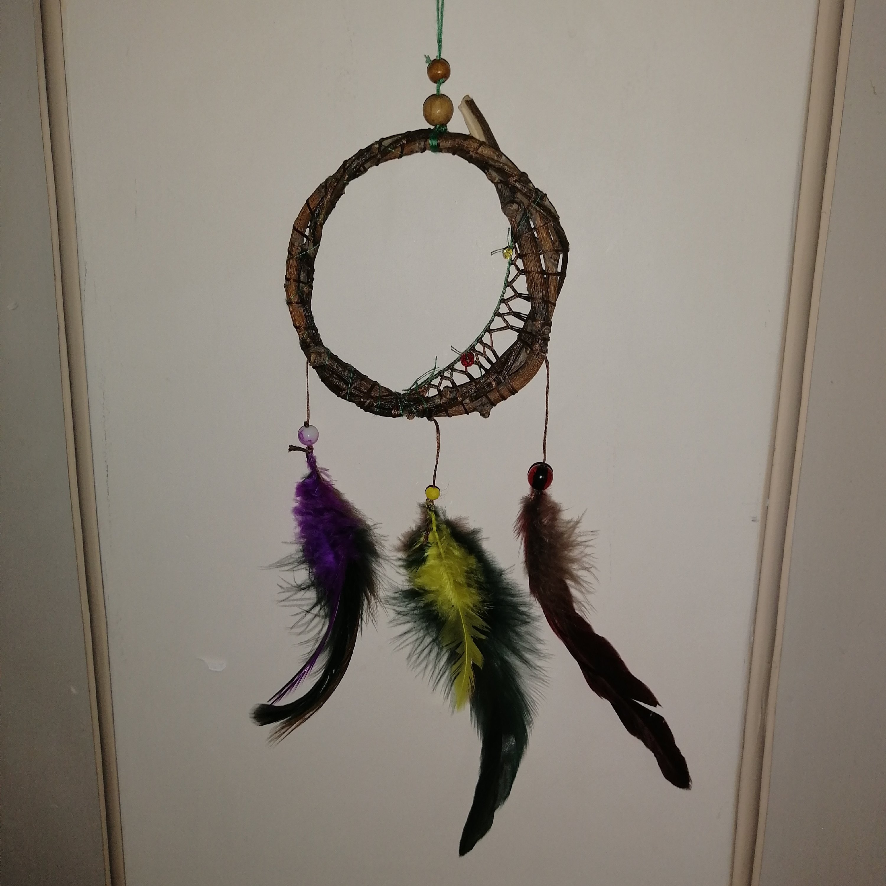 آویز دیوار یا ماشین که از حلقه چوبی و شکوفه های زرد، قرمز، نارنجی و... 