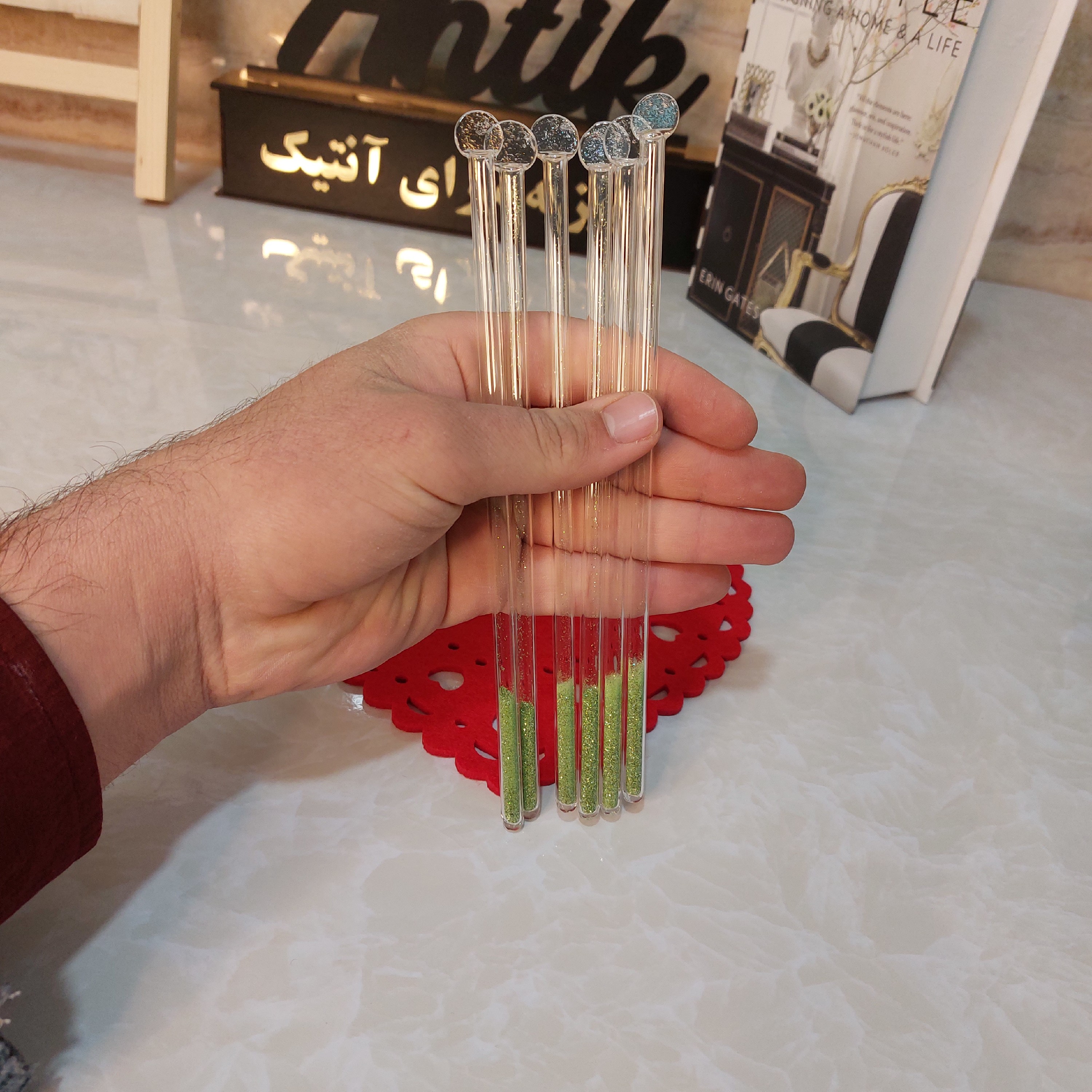 نی شیشه ای شربت داخل اکلیلی سبز مناسب همزدن شربت ونوشیدنی