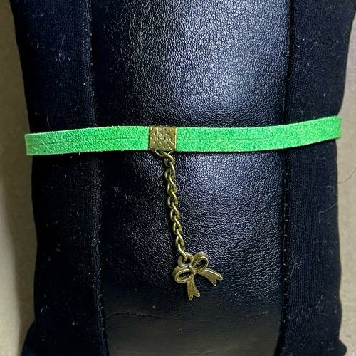 دستنبند تریشه چرمی مدل ساده سبز همراه با خرج کار برنزی طرح تاج و پاپیون و زنجیر برنزی