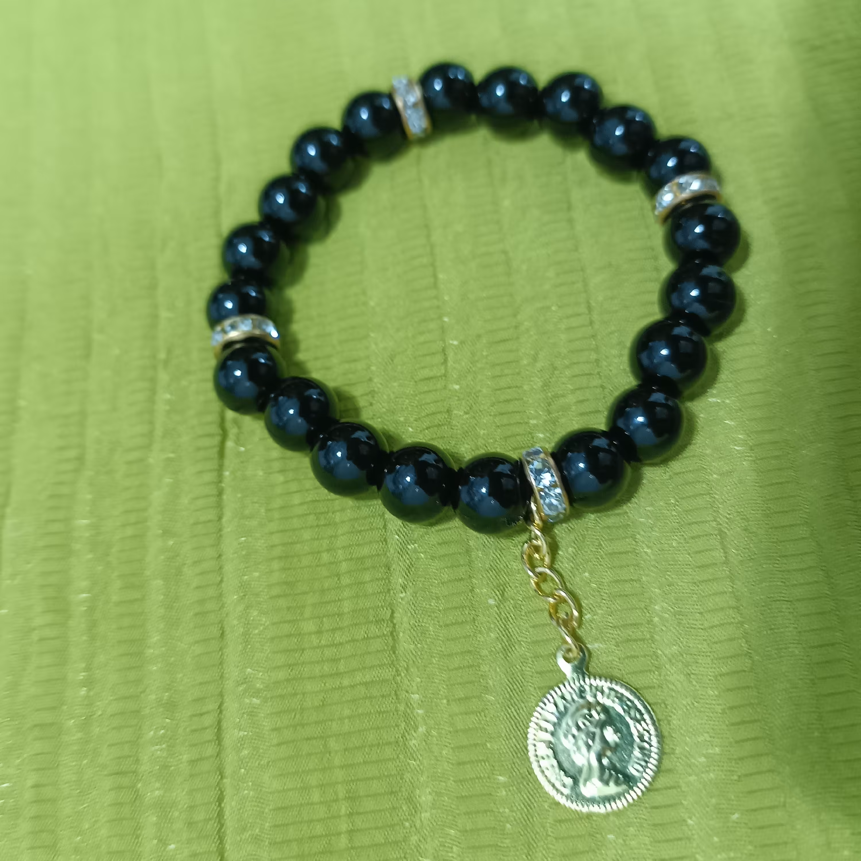 دستبند اونیکس براق مشکی با رینگ طلایی با آویز سکه