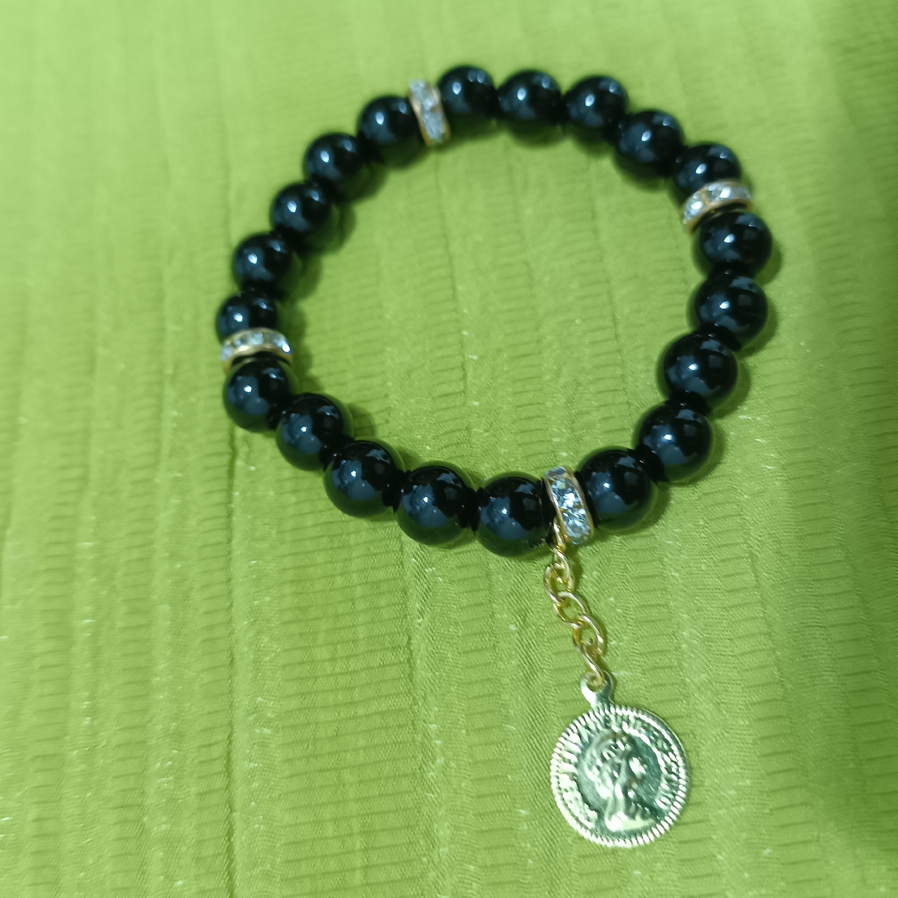 دستبند اونیکس براق مشکی با رینگ طلایی با آویز سکه