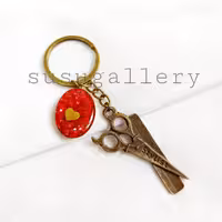 جاکلیدی برنزی شانه و قیچی آرایشگری با آویز قلبی رزینی قرمز