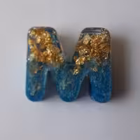 جاکلیدی رزینی حرف M همراه با ورقه طلایی و رنگ آبی