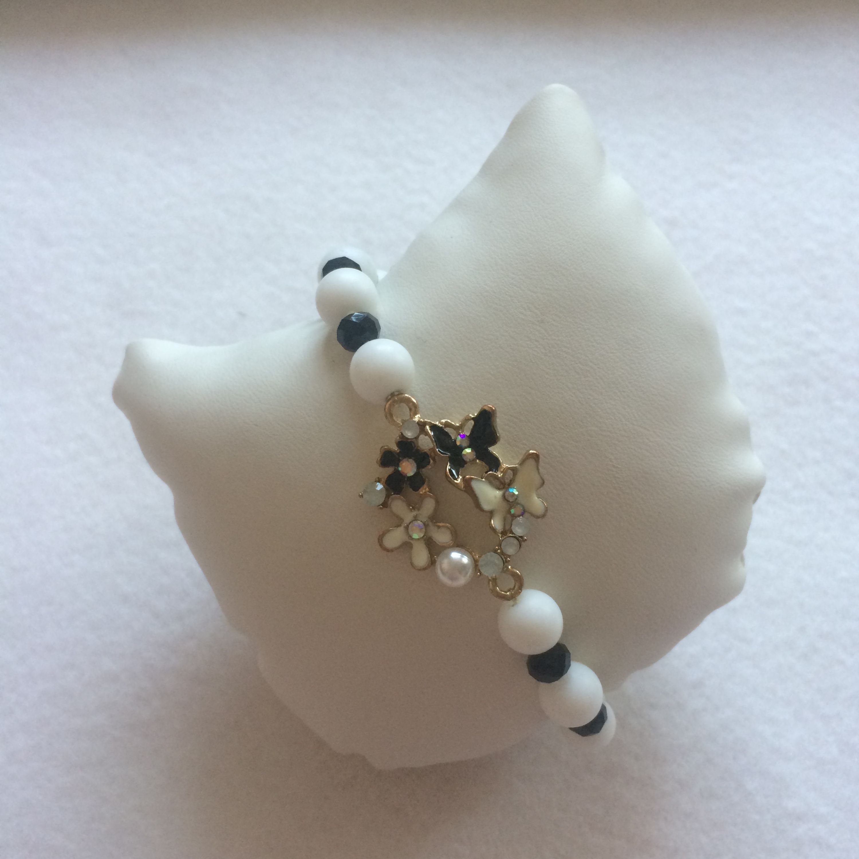 دستبند کشی سنگ اونیکس سفید و مهره کریستالی مات مشکی پروانه و گل و مروارید زرین ساز