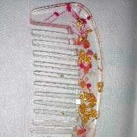 شانه رزینی شفاف دارای گل و ورق طلا