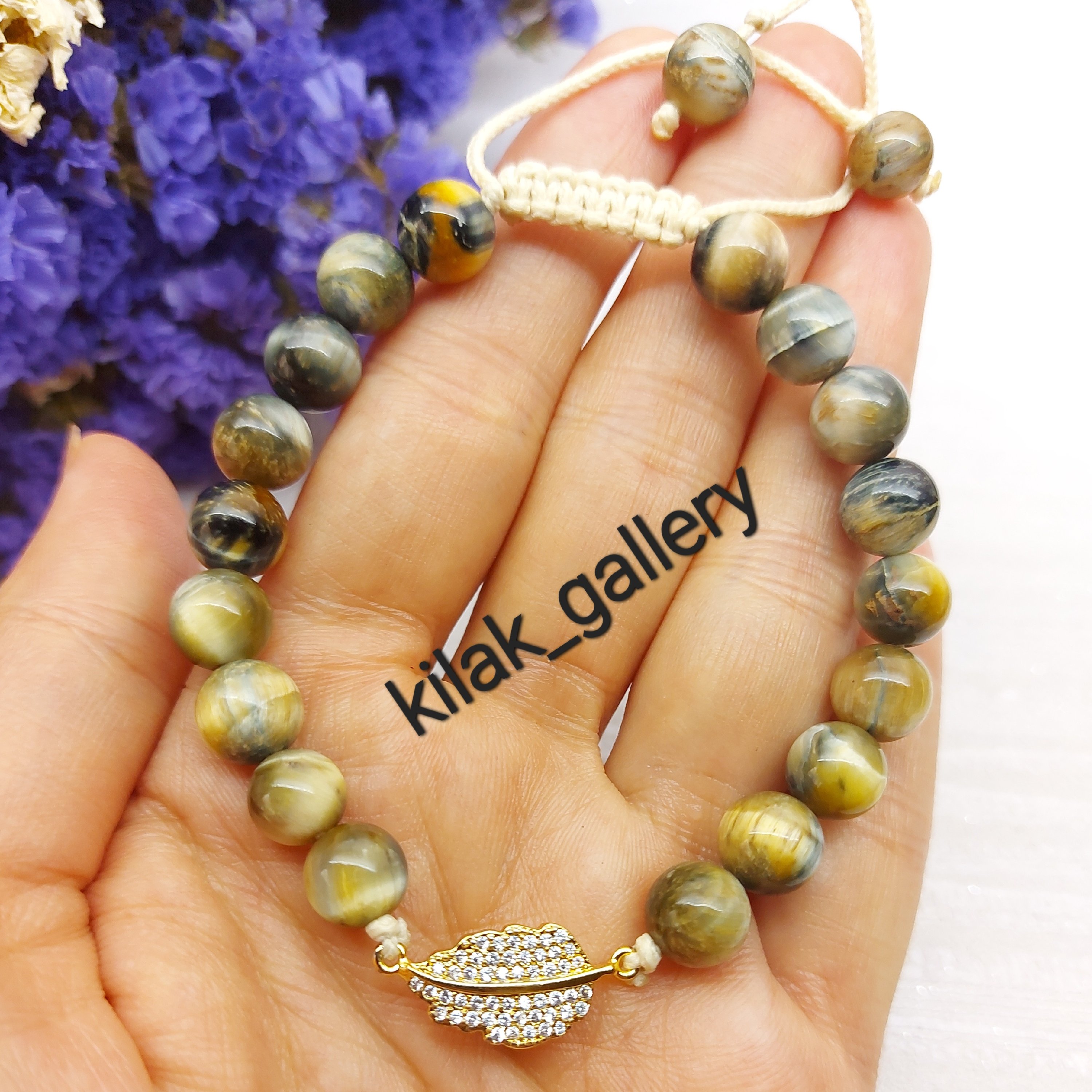 دستبند سنگی سنگ چشم ببر رنگ کاهی با پلاک طرح برگ از برند سوارسکی