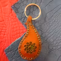 سرکلیدی  طرح بوته سرکج چرم گاو مرغوب رنگ قهوه ای تنها مشکلی که دارد دو پره گل پاره شده