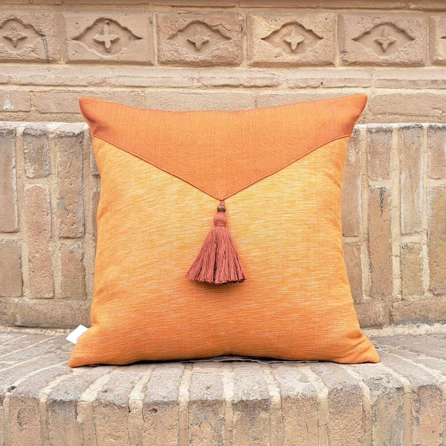 کوسن مربعی نارنجی منگوله دار با ابعاد 40 در 40