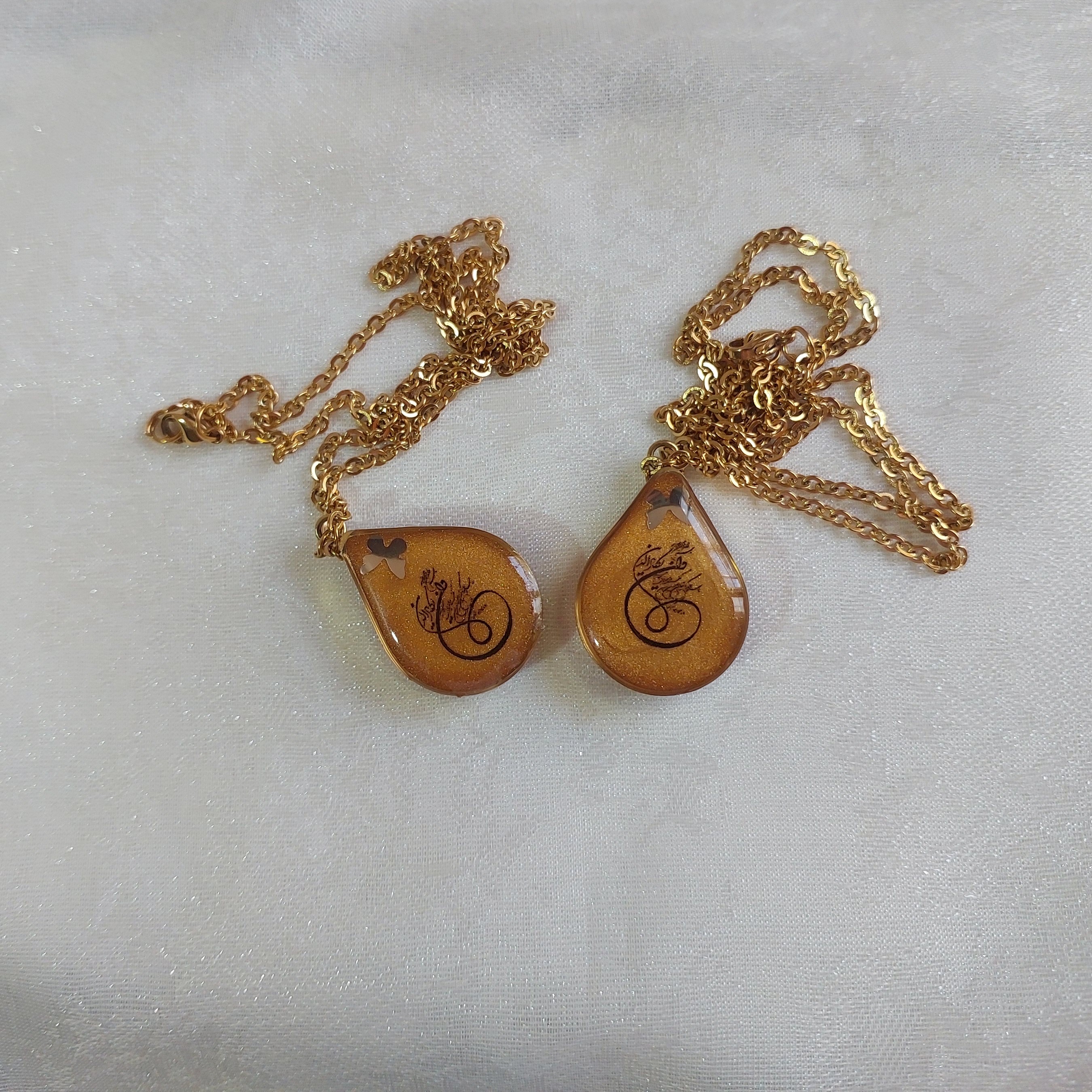 گردنبند رزینی مزین به وان یکاد و حرز امام جواد (ع) قاب برنج و یراق آلات رنگ ثابت