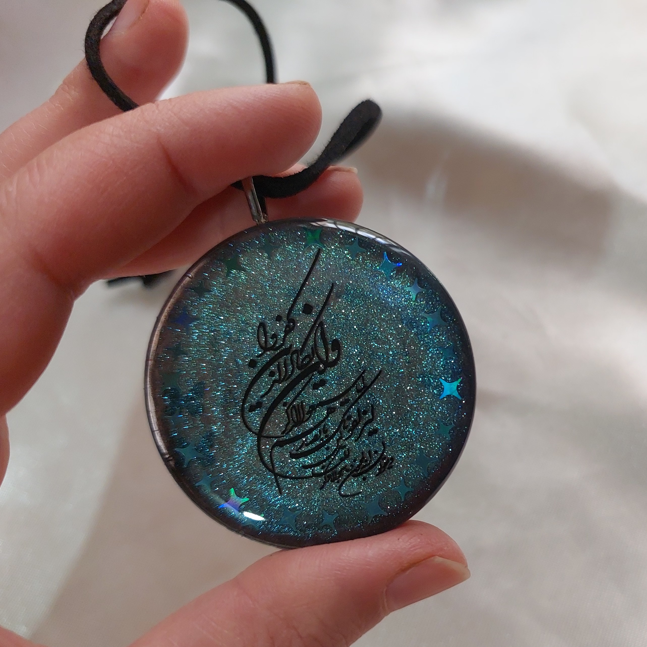 آویز ماشین رزینی مزین به وان یکاد و حرز امام جواد(ع) قاب استیل و بند چرمی با تزئین ستاره های هولوگرامی