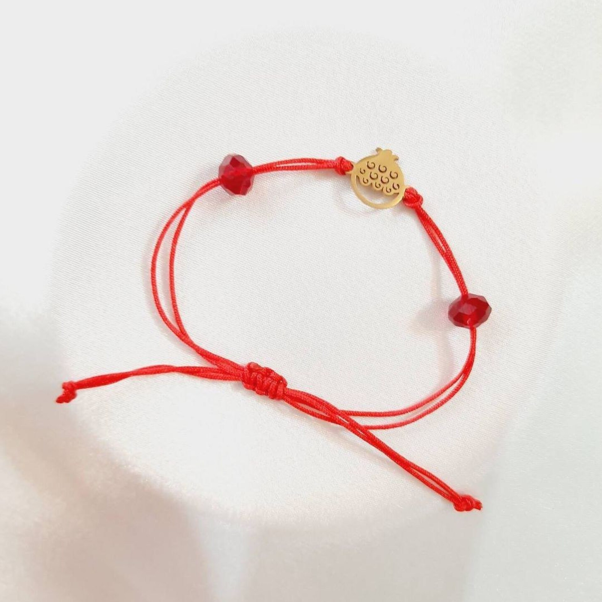 دستبند یلدایی نخی قرمز رنگ  گره ای با پلاک طرح انار استیل و دو عدد سنگ جید تراش زنبوری 