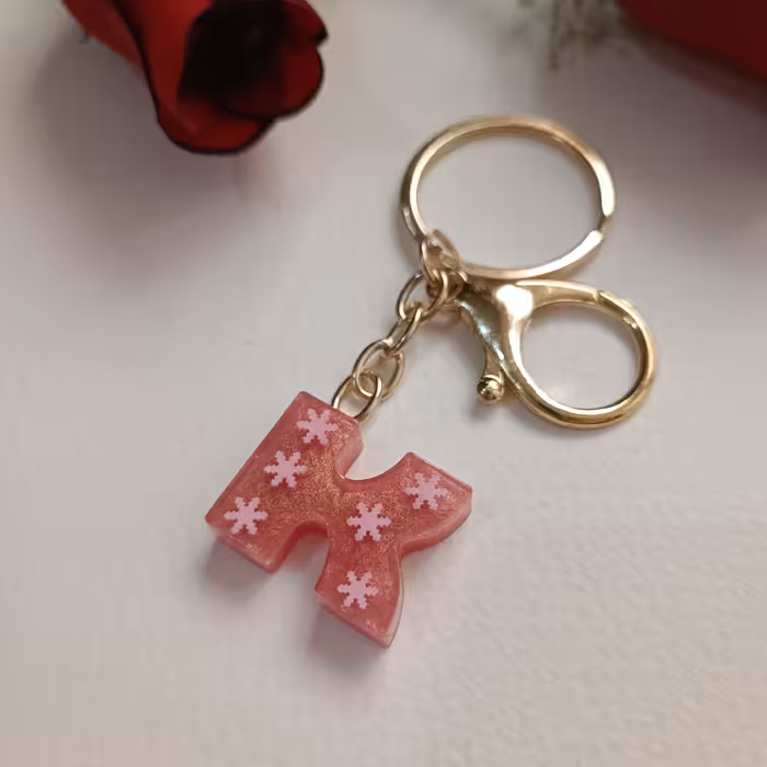 سرکلیدی و آویزکیف حرف انگلیسی رزینی رنگ ثابت و بدون حساسیت حرفK رزگلد با فیمو برف صورتی 