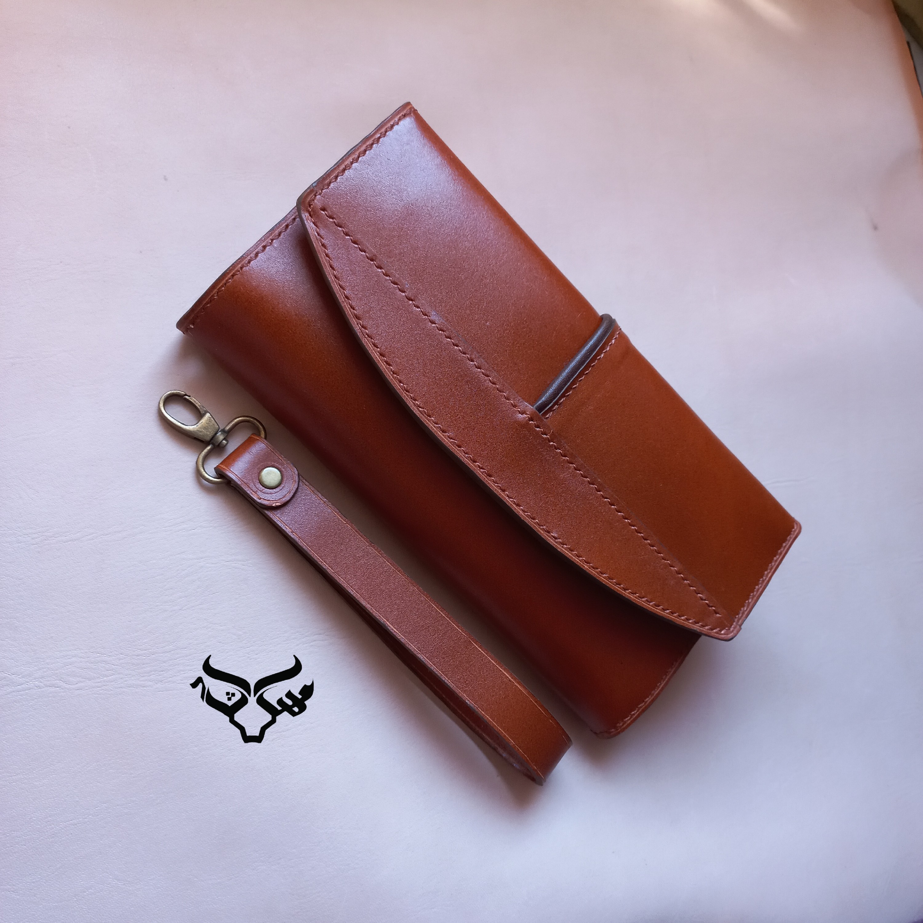 کیف دسته چک چرم گاوی رنگ عسلی تماما دستدوز لبه های محصول تمیز و یکدست رنگ خورده و  پرداخت شده 