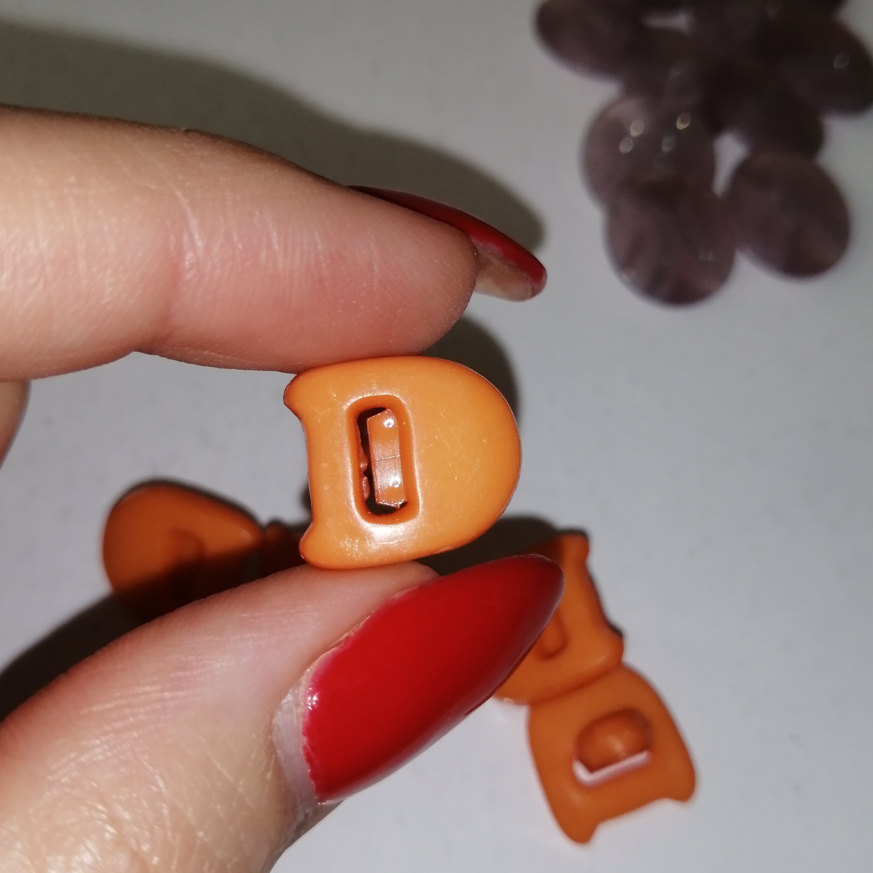 دکمه لباس حروف انگلیسی D نارنجی پلاستیکی بسته 9عددی     