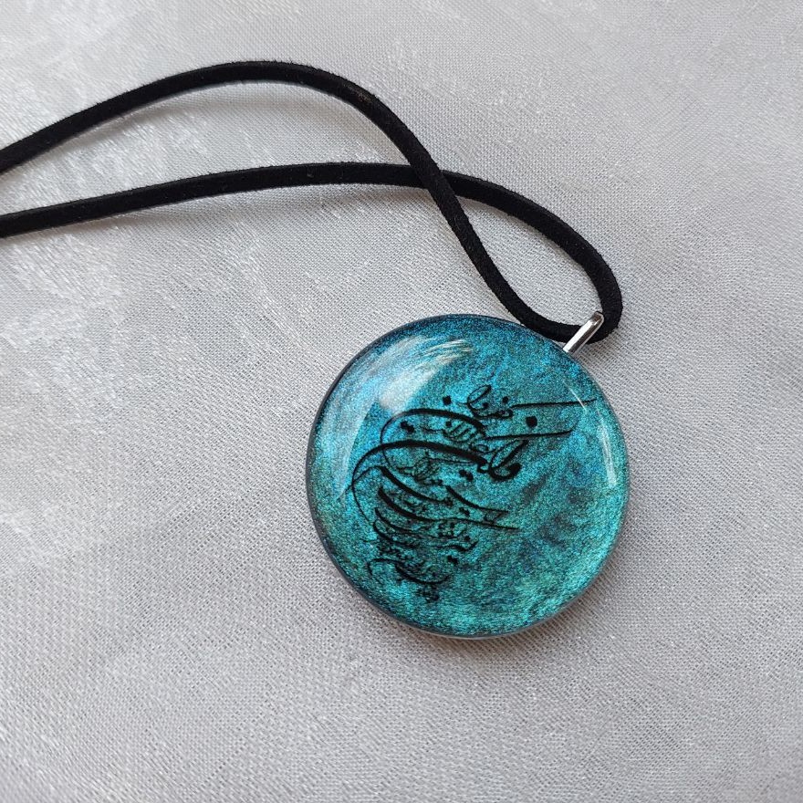 آویز ماشین رزینی مزین به وان یکاد و حرز امام جواد(ع) قاب استیل نقره ای رنگ ثابت و بند چرمی بسیار خوشرنگ