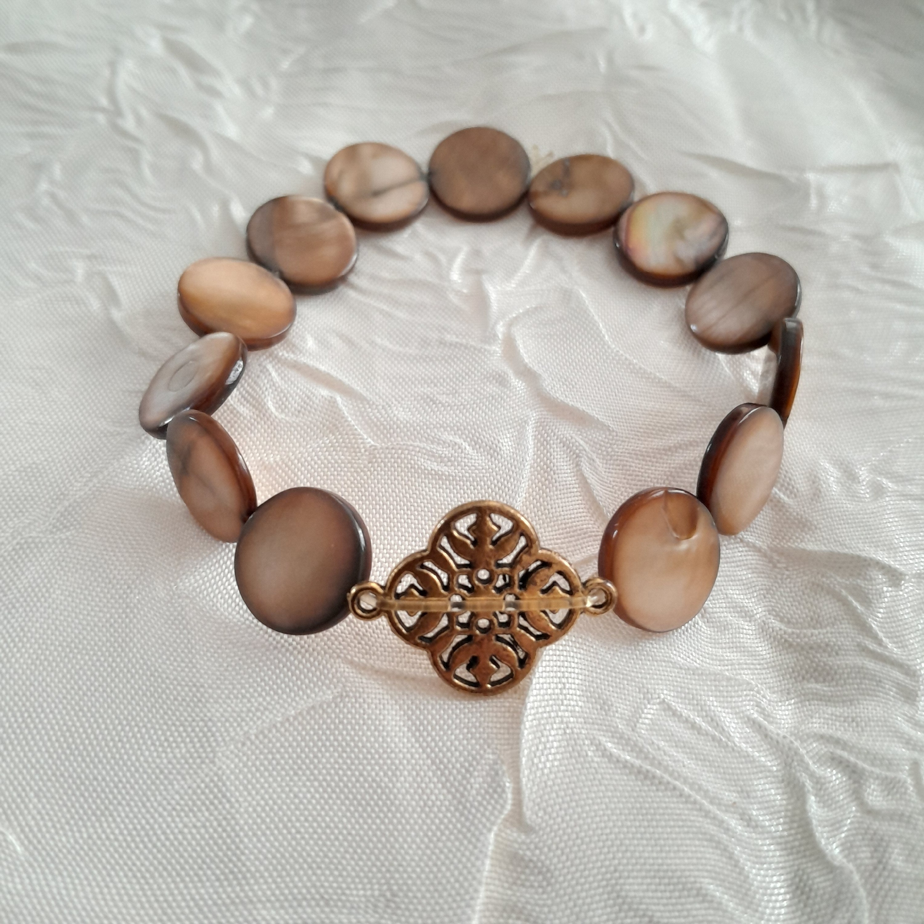 دستبند کشی صدفی قهوه ای با پلاک برنجی طلایی