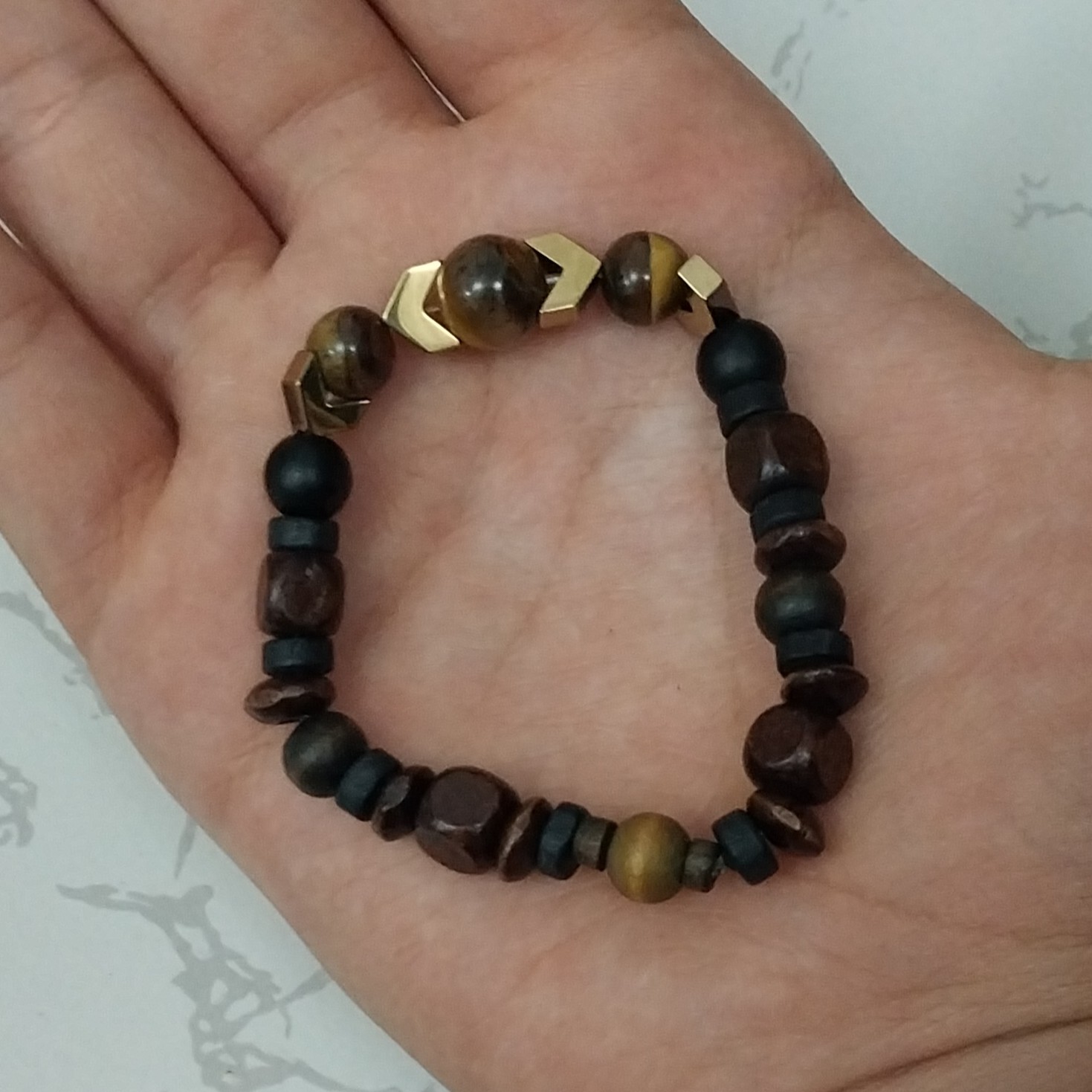 خرید و قیمت دستبند اونیکس مشکی مات و سنگ چشم ببر  و 2 مهره سنگ حدید رنگ طلایی کد 22